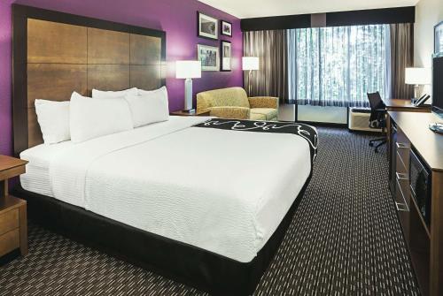 a hotel room with a large bed and a desk at La Quinta by Wyndham Rancho Cordova Sacramento in Rancho Cordova