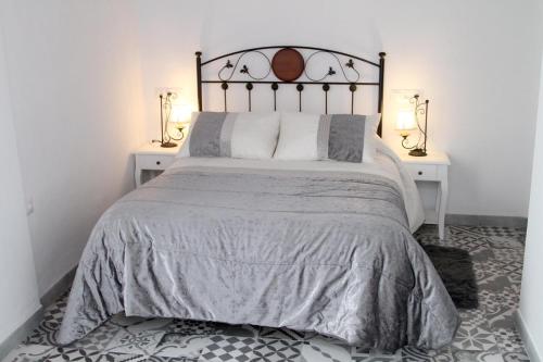 um quarto com uma cama grande e 2 mesas de cabeceira em Casa Atahona - Casita con Encanto em Medina Sidonia