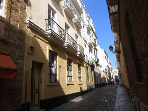 
a city street with buildings and a clock on the side of the street at Summer Cádiz in Cádiz
