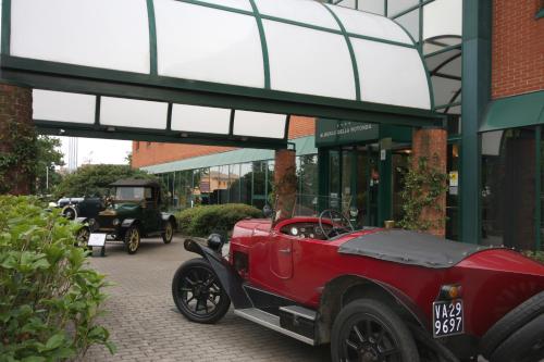 an old red car parked in front of a building at Hotel Della Rotonda in Saronno