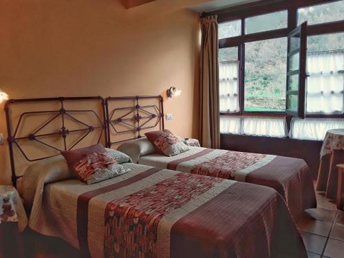 a bedroom with two beds and a window at La Corona del Auteiro in Valle de Lago