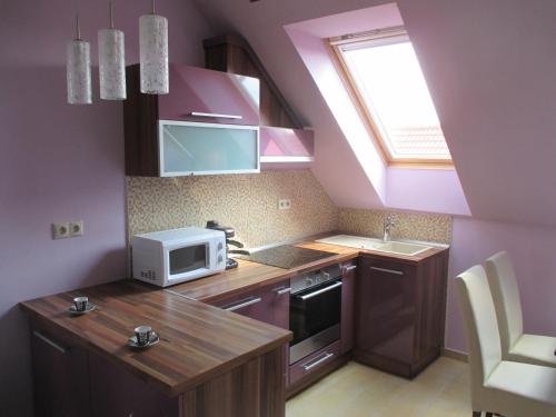 a small kitchen with a sink and a microwave at Alpha Apartman Sárvár in Sárvár