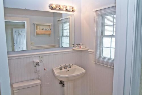 bagno bianco con lavandino e specchio di The Hawthorne a Chatham