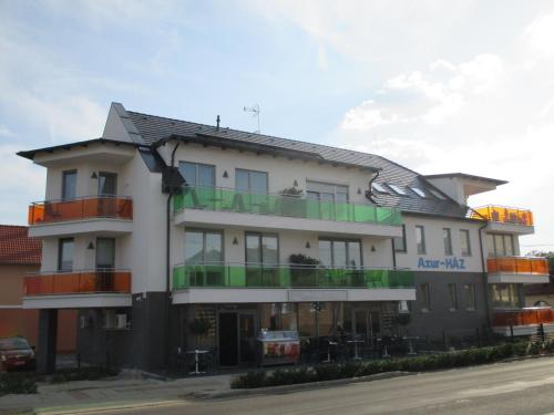 a large white building with green balconies on a street at Alpha Apartman Sárvár in Sárvár