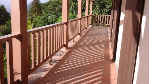 a wooden walkway leading to a balcony with trees at Trois Piton Apartments in Pont Cassé