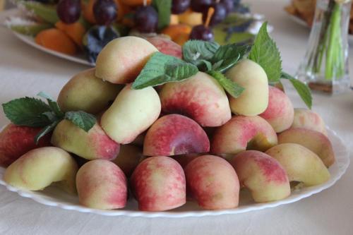 a plate with a pile of fruit on a table at Hotel Angelas in Utena