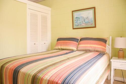 a bedroom with a bed with a striped comforter at Coral Getaway at Fisherman's Point in Ocho Rios