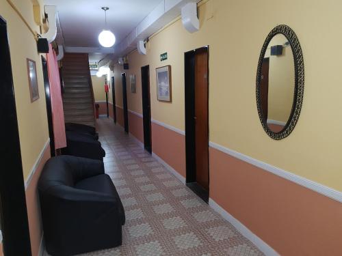 a hallway with couches and a mirror on the wall at Hotel Paris in San Martín