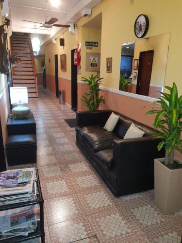 a waiting room with a leather couch in a lobby at Hotel Paris in San Martín