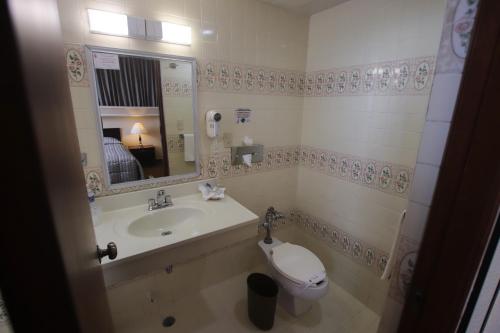 a bathroom with a sink and a toilet and a mirror at Hotel Montecarlo in Tampico