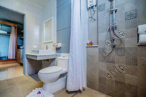 a bathroom with a toilet and a shower and a sink at The Rubber Hotel Phuket in Thalang