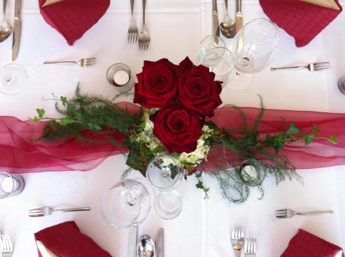 a table set for a wedding with red roses at Hotel-Restaurant Gollner in Lebring