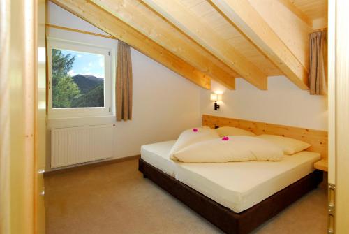 a bedroom with a bed and a window at Residence Remi in Senales