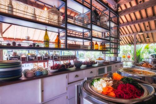 a kitchen with plates of food on a counter at Hotel Komune and Beach Club Bali in Keramas