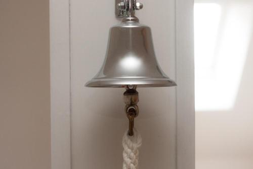 a lamp hanging on a door with a white curtain at 50002 Captains Loft in Carolinensiel