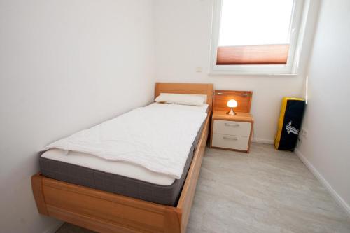 ein kleines Schlafzimmer mit einem Bett und einem Fenster in der Unterkunft 50228... in Carolinensiel