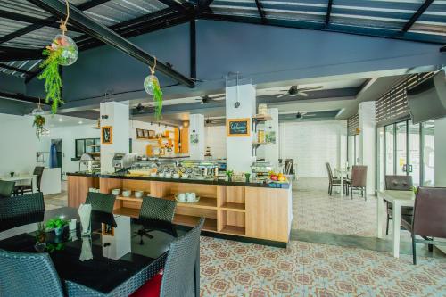 a kitchen and dining room with tables and chairs at The Rubber Hotel Phuket in Thalang