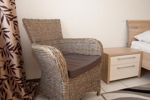 een rieten stoel in een slaapkamer naast een bed bij 50140... in Carolinensiel