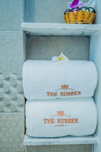 a stack of towels sitting on a shelf at The Rubber Hotel Phuket in Thalang