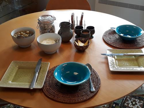 una mesa de madera con platos, tazones y utensilios en Behind the Bike Sheds, en Waipiata