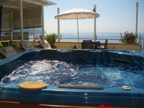 un bain à remous dans une terrasse avec un parasol dans l'établissement E Poi...Ravello, à Ravello