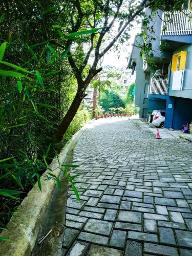 a cobblestone street with a tree and buildings at 87 Guesthouse in Baguio