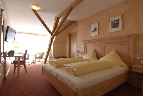 a bedroom with two beds and a table with chairs at Weinhotel / Gasthaus zur Sonne in Ihringen