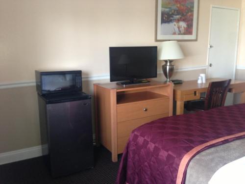 a hotel room with a bed and a television on a dresser at Americas Best Value Inn - Downtown Oakland/Lake Merritt in Oakland