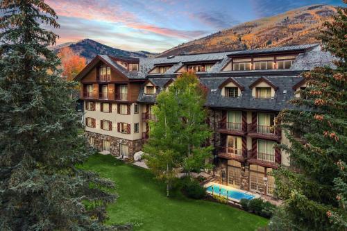 an exterior view of a large building with trees at Tivoli Lodge in Vail