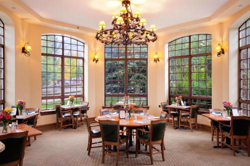 a dining room with tables and chairs and windows at Tivoli Lodge in Vail