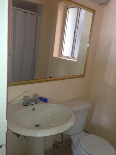 a bathroom with a sink and a toilet and a mirror at Americas Best Value Inn - Downtown Oakland/Lake Merritt in Oakland