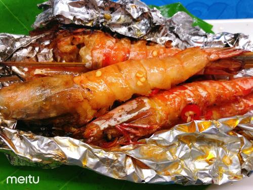 a plate of food with lobster wrapped in tin foil at Grand Blue Beach Hotel in Boracay