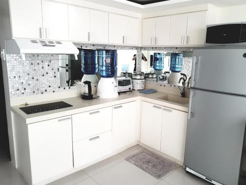 a kitchen with white cabinets and blue appliances at On Top of the World Loft in Cebu City