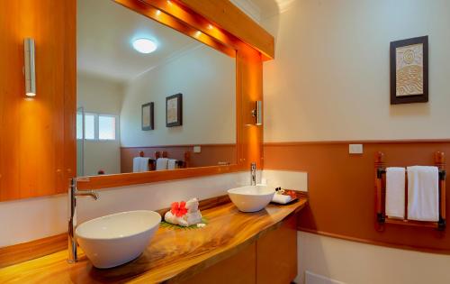 a bathroom with two sinks and a large mirror at Bedarra Beach Inn in Korotogo