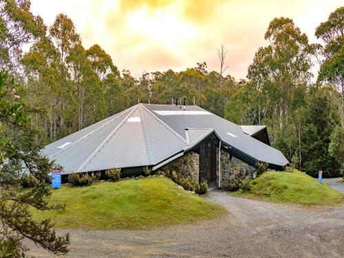 a house with a metal roof on top of a field at Discovery Parks - Cradle Mountain in Cradle Mountain