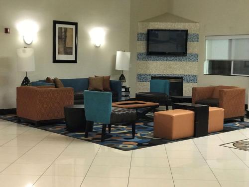 a living room with a couch and chairs and a fireplace at West Valley Inn in West Valley City