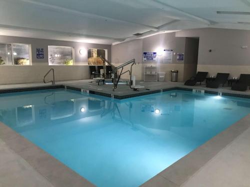 a large swimming pool with blue lighting in a hotel room at West Valley Inn in West Valley City