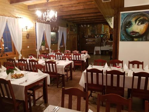 a restaurant with tables and chairs and a painting on the wall at Jasminum in Słupsk