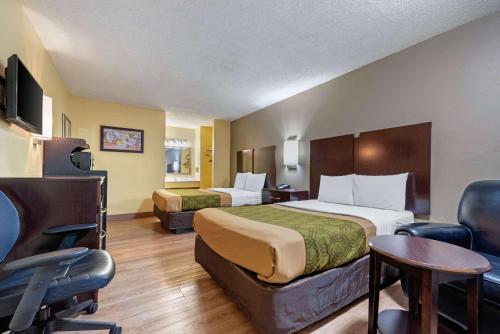 a hotel room with two beds and a table and chairs at Econo Lodge Lexington Southeast in Lexington