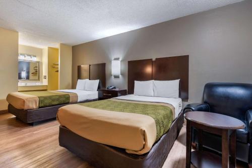 ein Hotelzimmer mit 2 Betten und einem Stuhl in der Unterkunft Econo Lodge in Lexington