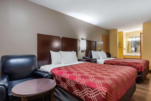 a hotel room with two beds and a chair at Econo Lodge Lexington Southeast in Lexington