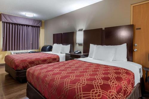 a hotel room with two beds and a chair at Econo Lodge Lexington Southeast in Lexington