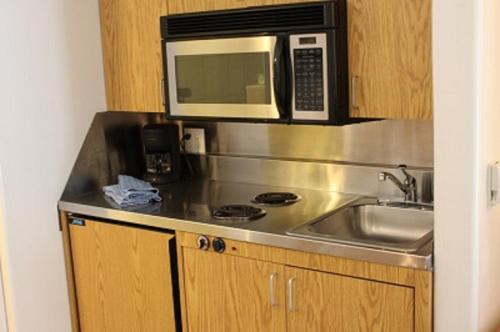 a kitchen with a sink and a microwave at St Moritz Lodge and Condominiums in Aspen