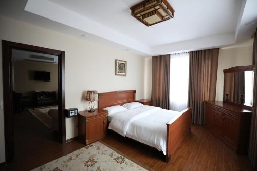 เตียงในห้องที่ Bokhtar Apart Hotel