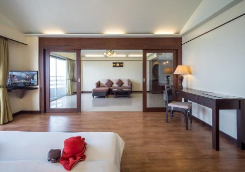 a living room with a white couch and a desk at Grand Jomtien Palace Hotel - SHA Extra Plus in Jomtien Beach