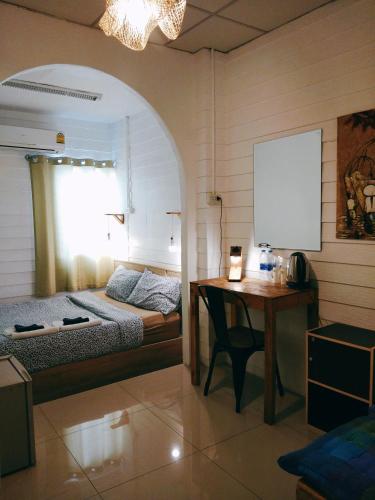 a bedroom with a bed and a desk and a table at La Locanda in Bangkok