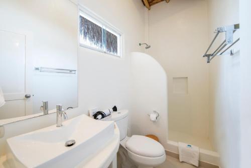 La salle de bains blanche est pourvue de toilettes et d'un lavabo. dans l'établissement Qalma Punta Sal, à Canoas de Punta Sal