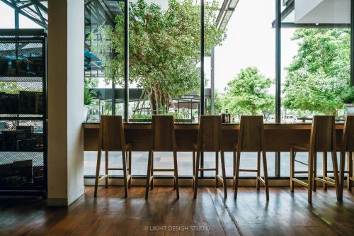 a long table with chairs in a room with windows at The VELO'S Hotel and Pumptrack in Aranyaprathet