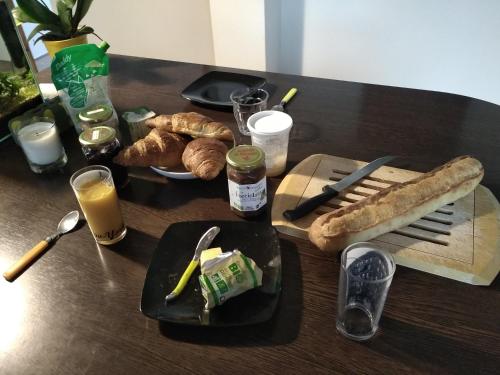 una mesa cubierta con platos de comida y pan en A la campagne, au calme en Montérolier
