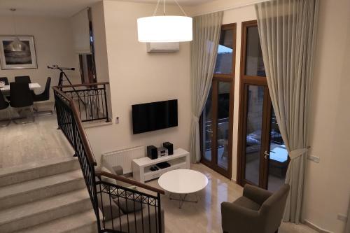 a living room with a television and a table and chairs at Villa HERMIONA in Kouklia